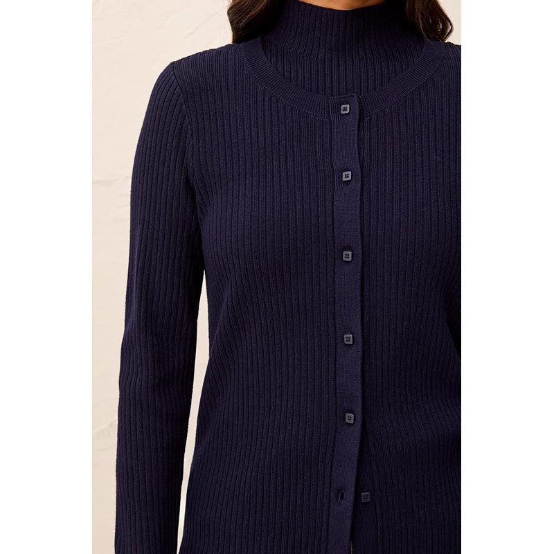 A close-up of a woman wearing a dark navy ribbed knit cardigan sweater with small square front buttons.