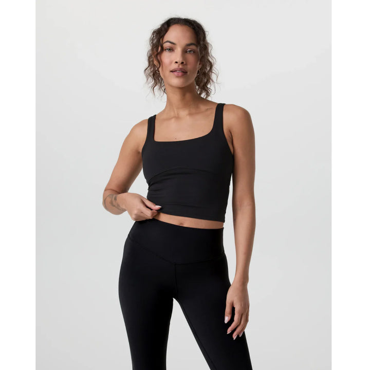 Woman wearing a black athletic outfit on a white background