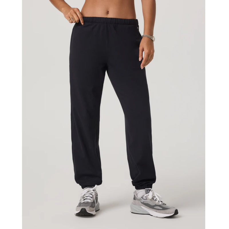 Person wearing black sweatpants on a light gray background