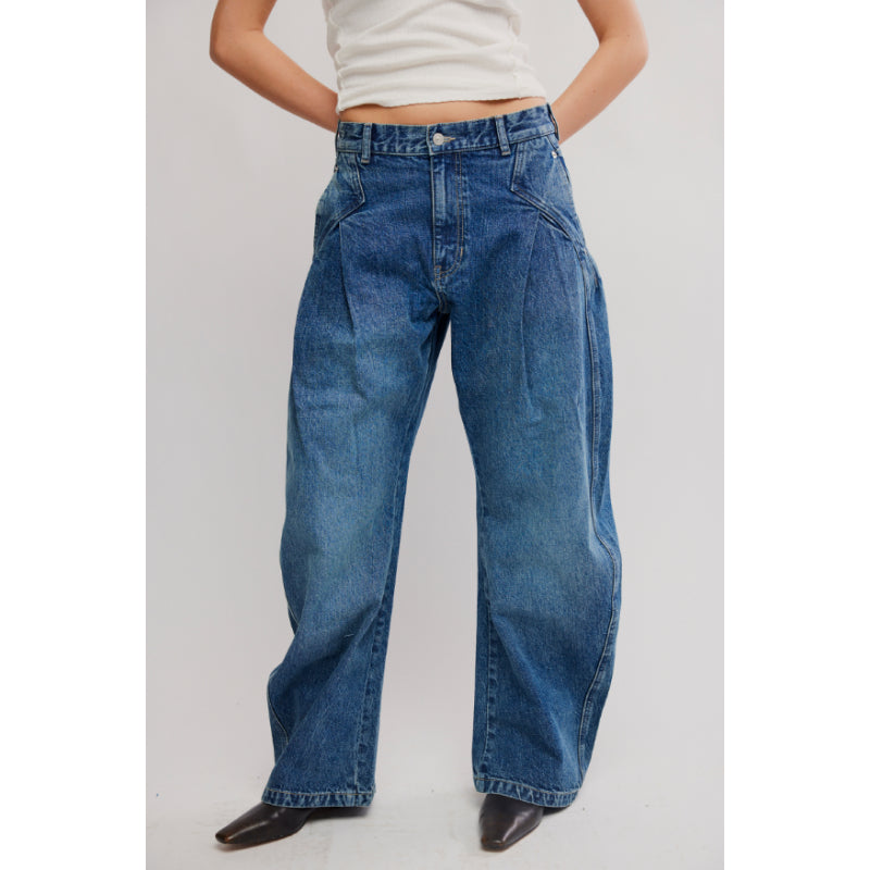 Person wearing blue jeans on a plain background