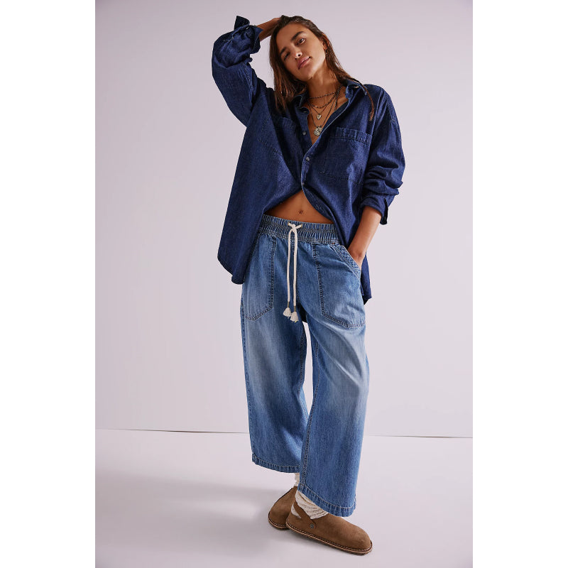 Woman wearing a blue denim jacket and jeans on a white background