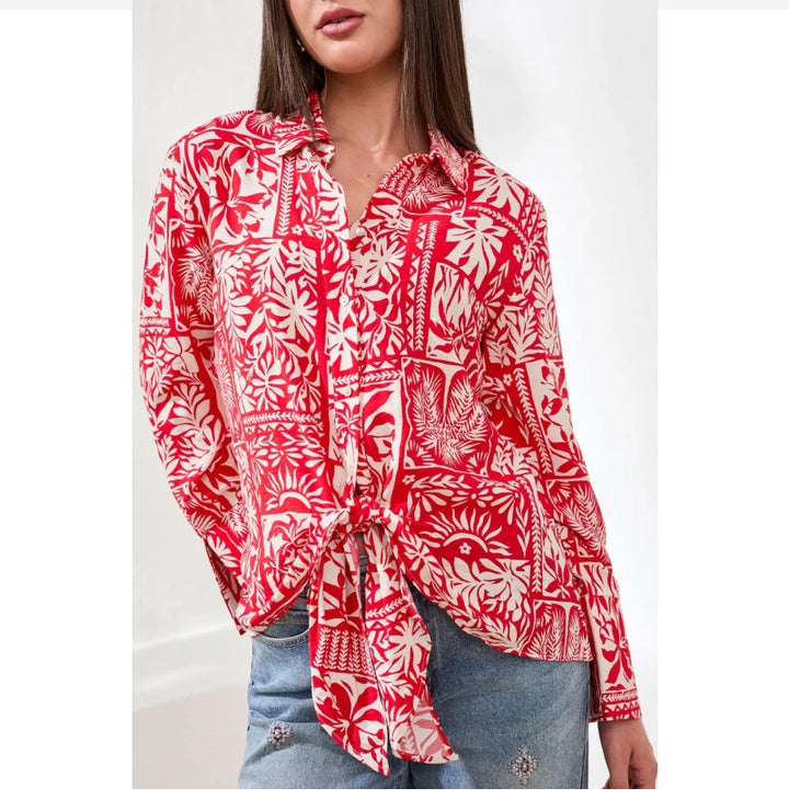 Woman wearing a red and white patterned shirt with a blurred background