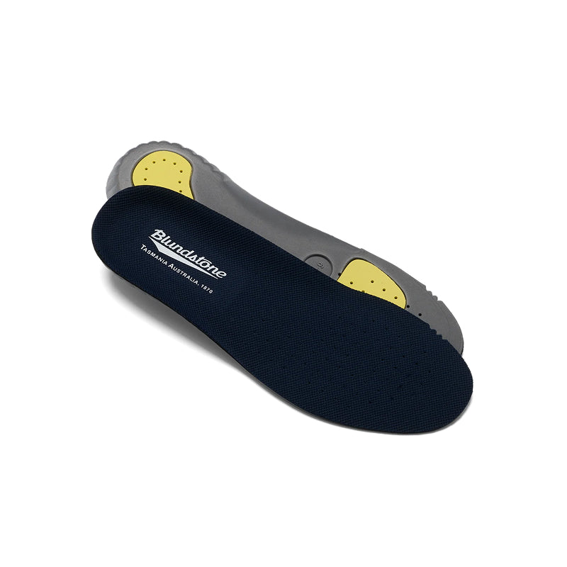A pair of Blundstone orthopedic shoe insoles, with one navy blue upper and one gray lower, showing yellow footbed inserts, on a white background.