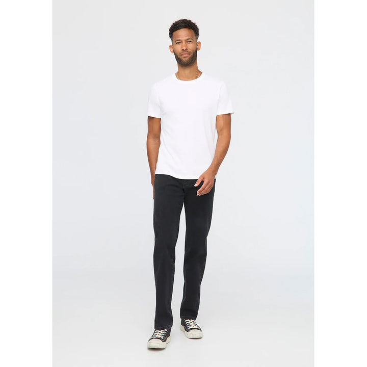 Man wearing a white t-shirt and black jeans on a white background