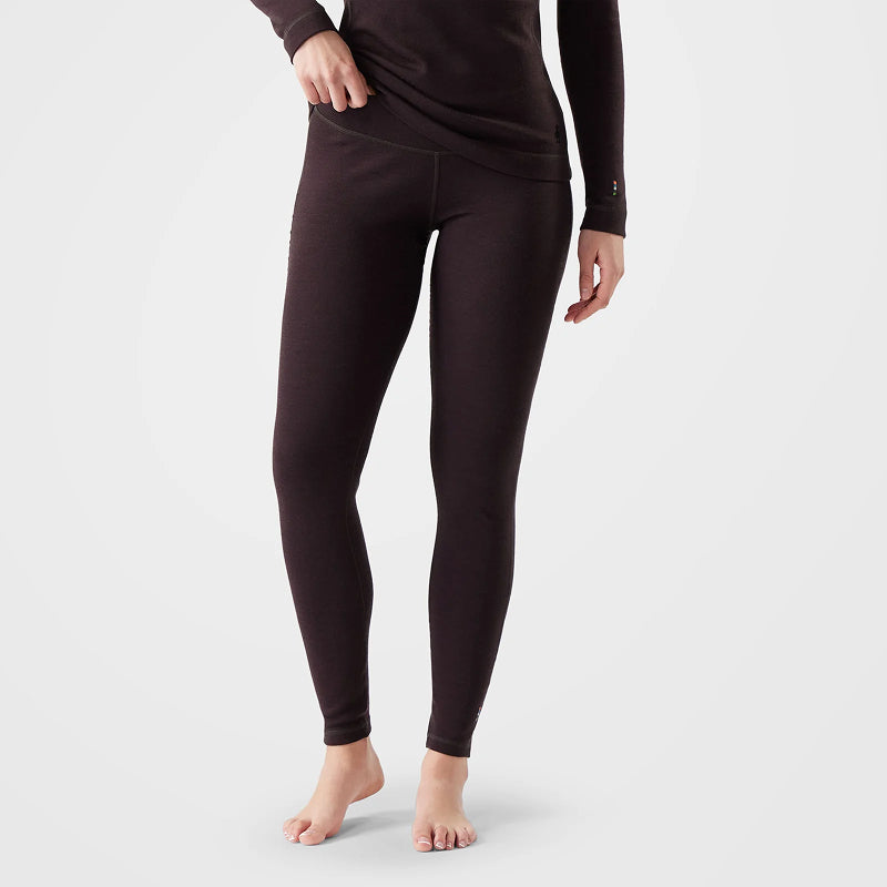 A model wearing dark brown thermal leggings and a matching long-sleeve top, shown from the waist down against a light gray studio background.