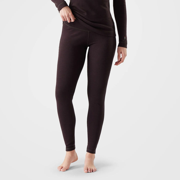 A model wearing dark brown thermal leggings and a matching long-sleeve top, shown from the waist down against a light gray studio background.