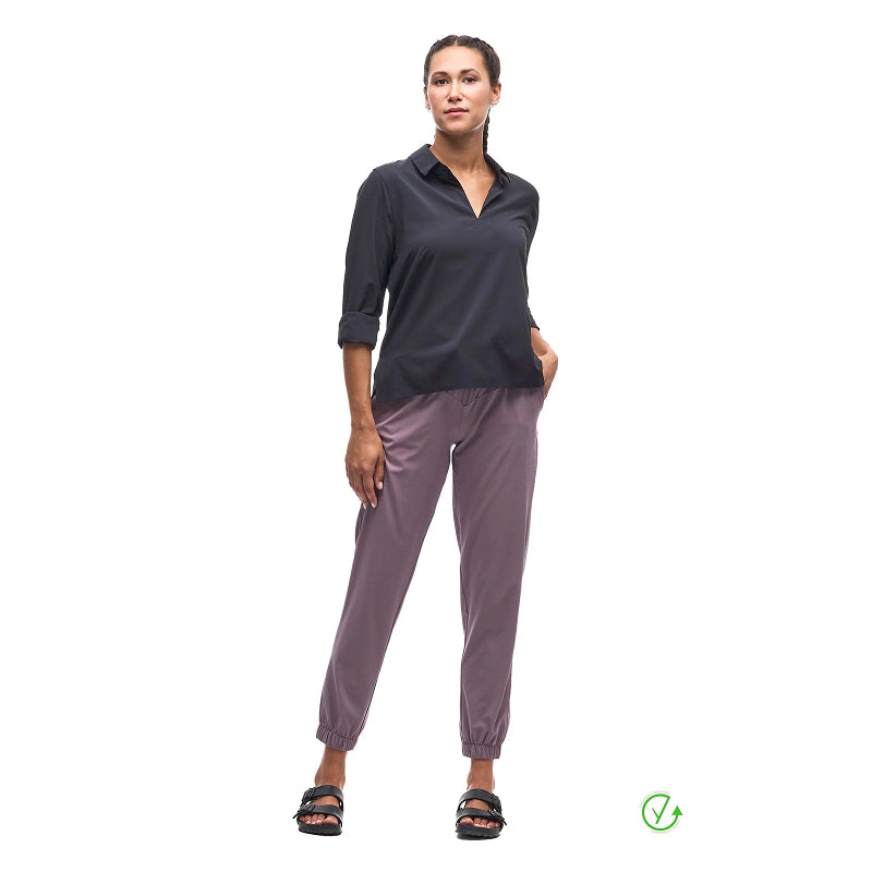Woman wearing a dark shirt and purple pants on a white background