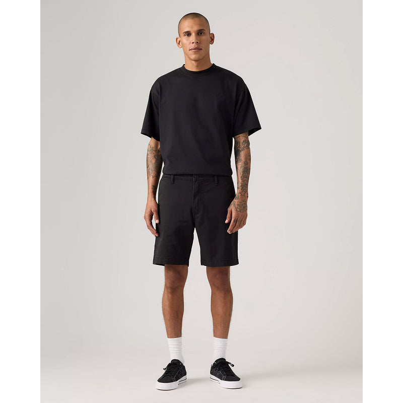 Man wearing a black t-shirt and shorts on a plain background