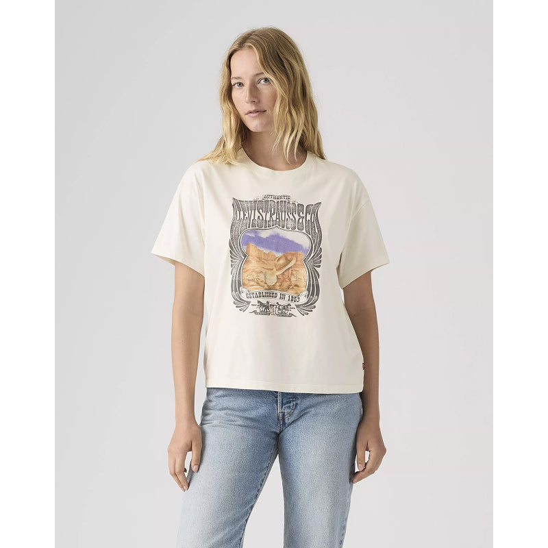 Woman wearing a white t-shirt with graphic design on a plain background