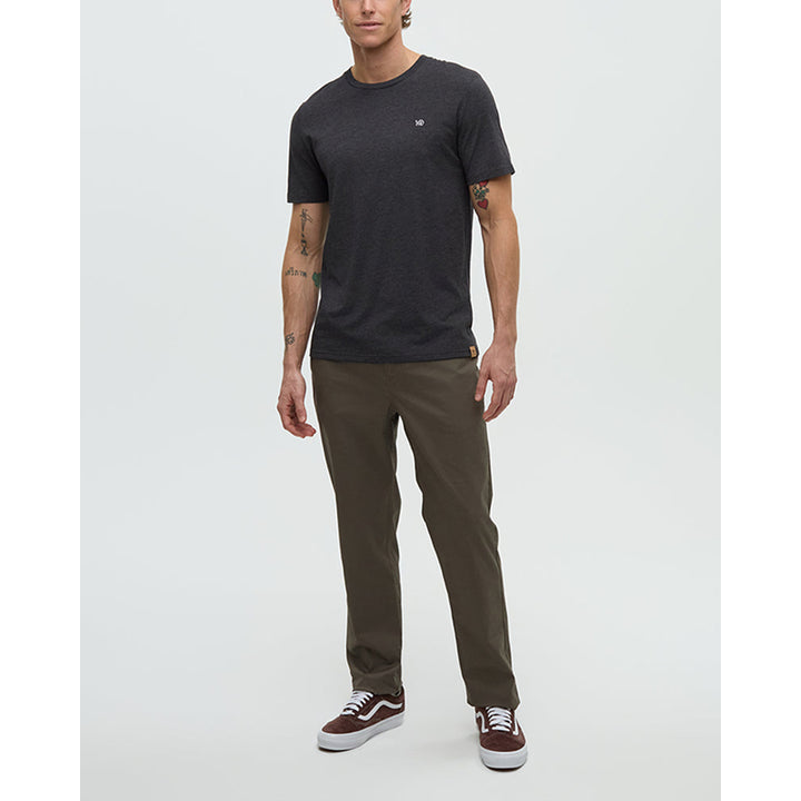 Man wearing a black t-shirt and green pants on a white background