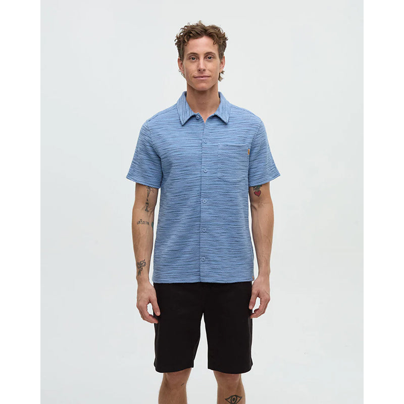 Man wearing a blue striped shirt and black shorts on a white background