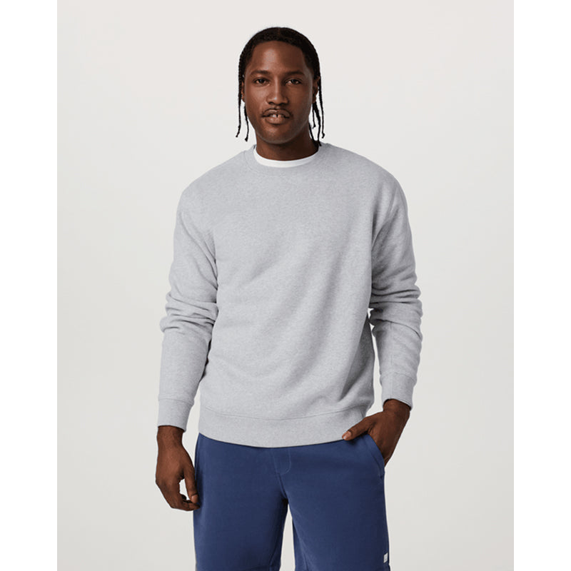 Man wearing a gray sweater and blue pants on a white background