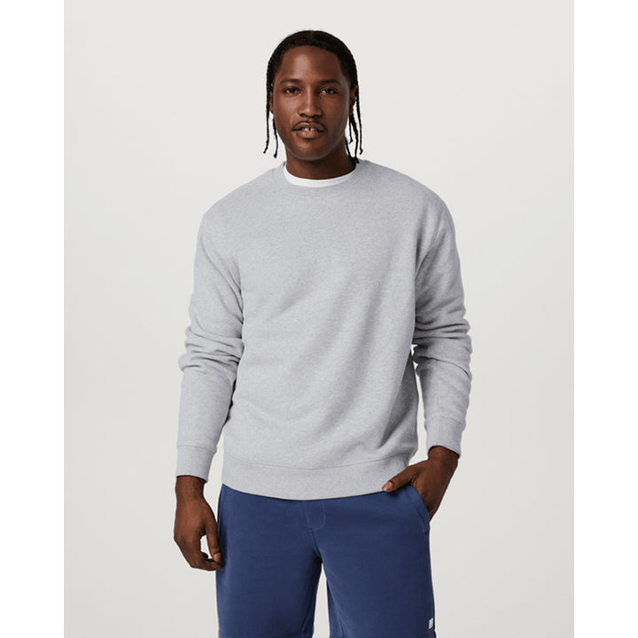 Man wearing a gray sweater and blue pants on a white background