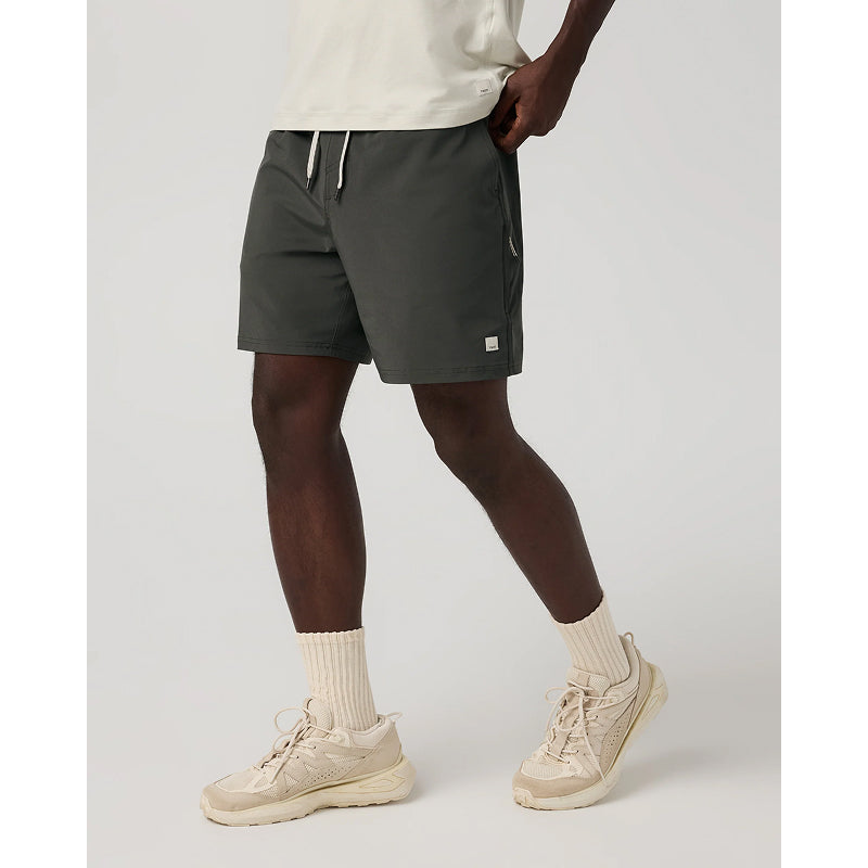 Person wearing dark gray shorts with a brand logo on a light gray background