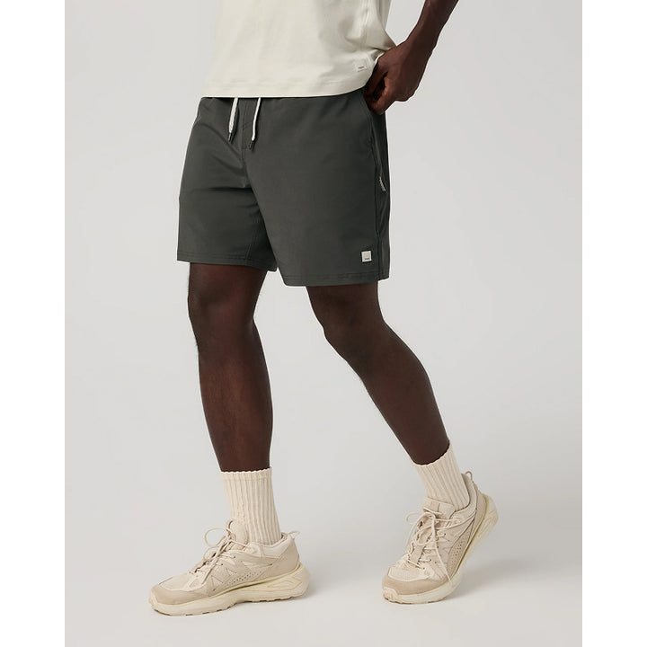 Person wearing dark gray shorts with a brand logo on a light gray background