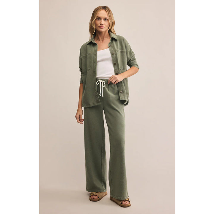 Woman wearing a green outfit with a beige background